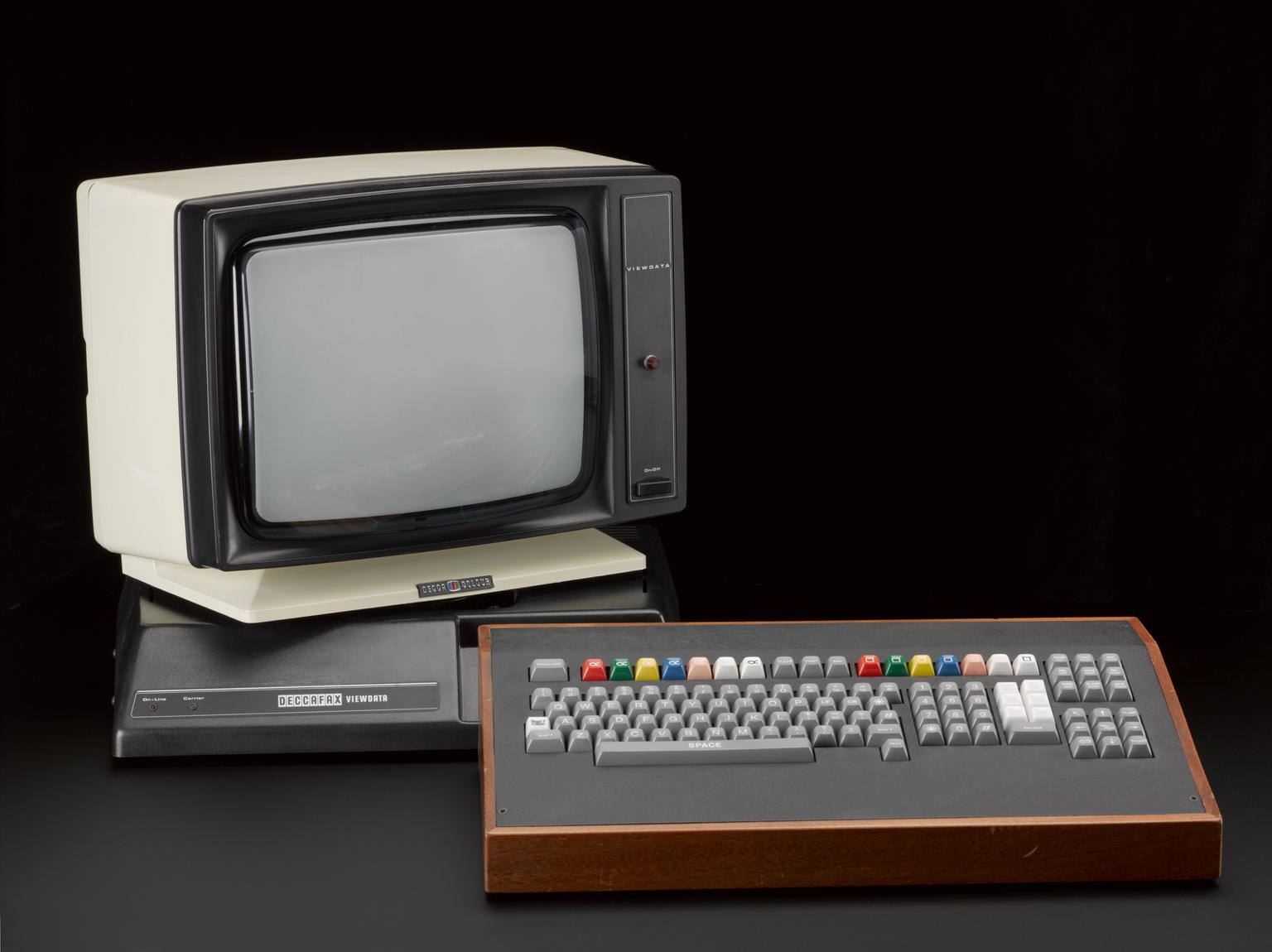 A Deccafax Viewdata terminal: a cream-and-black CRT monitor on a base unit labelled DECCAFAX VIEWDATA, paired with a wood-trimmed keyboard with colourful red, green, yellow and blue function keys