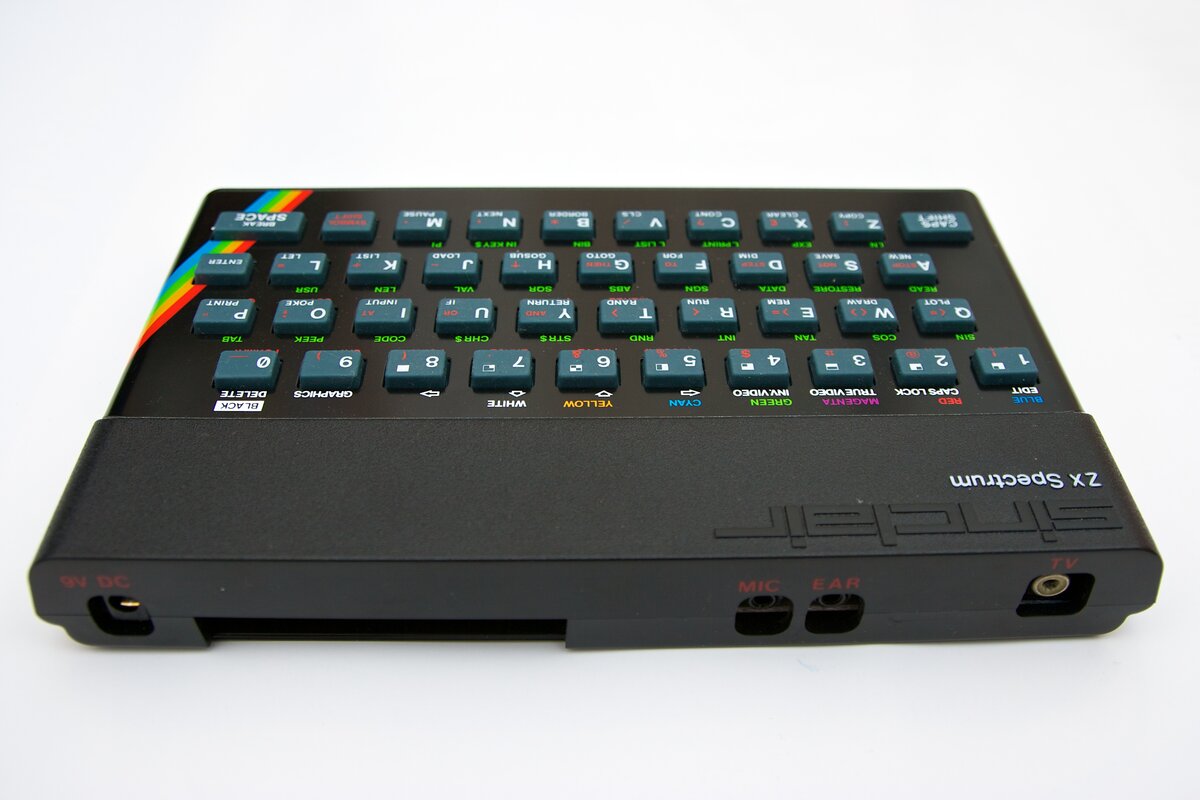 A Sinclair ZX Spectrum 48K rubber-keyed computer photographed at an angle, showing the rainbow stripe and full keyboard